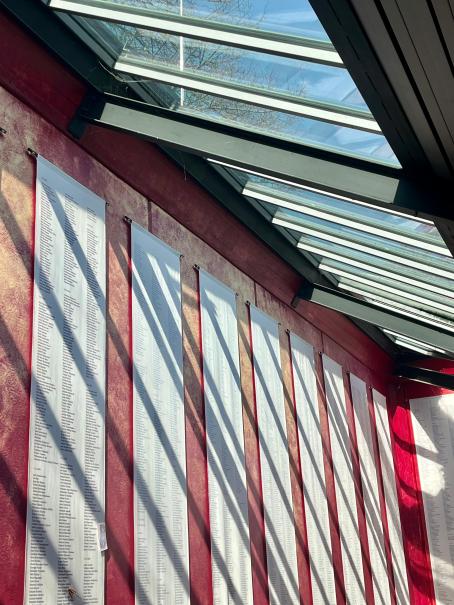 Die Gedenkhalle mit den Stoffbahnen, die die Namen der namentlich bekannten Verstorbenen aufzählt, nach Datum sortiert.